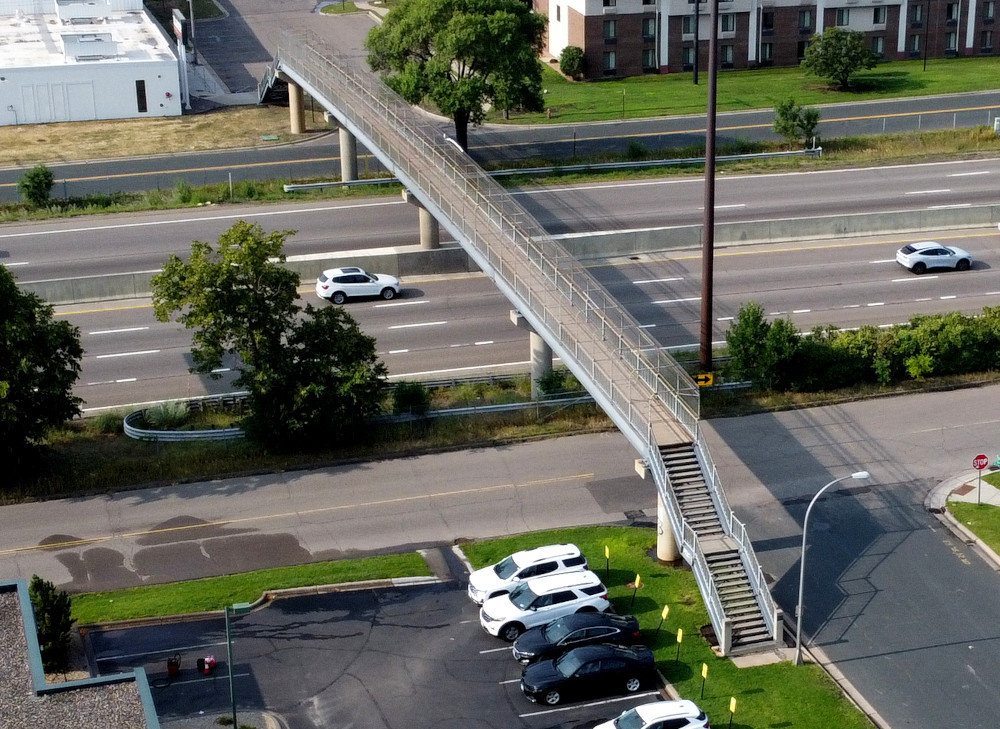 Aerial shot of the pedestrian bridge from a new angle, highlighting the fact that both ends of the bridge have stairs and no ramps.