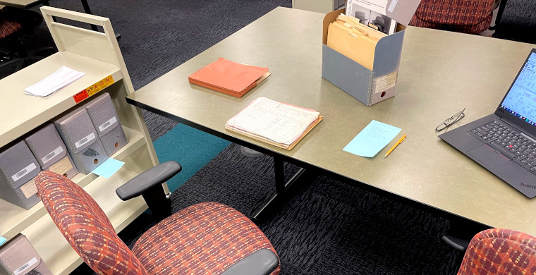 Photo of a desk, some documents, and a folder open on a table.